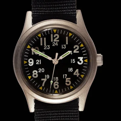 MWC Classic 1970s patroon MIL-W-46374 patroon militair horloge op een zwarte militaire webbing band